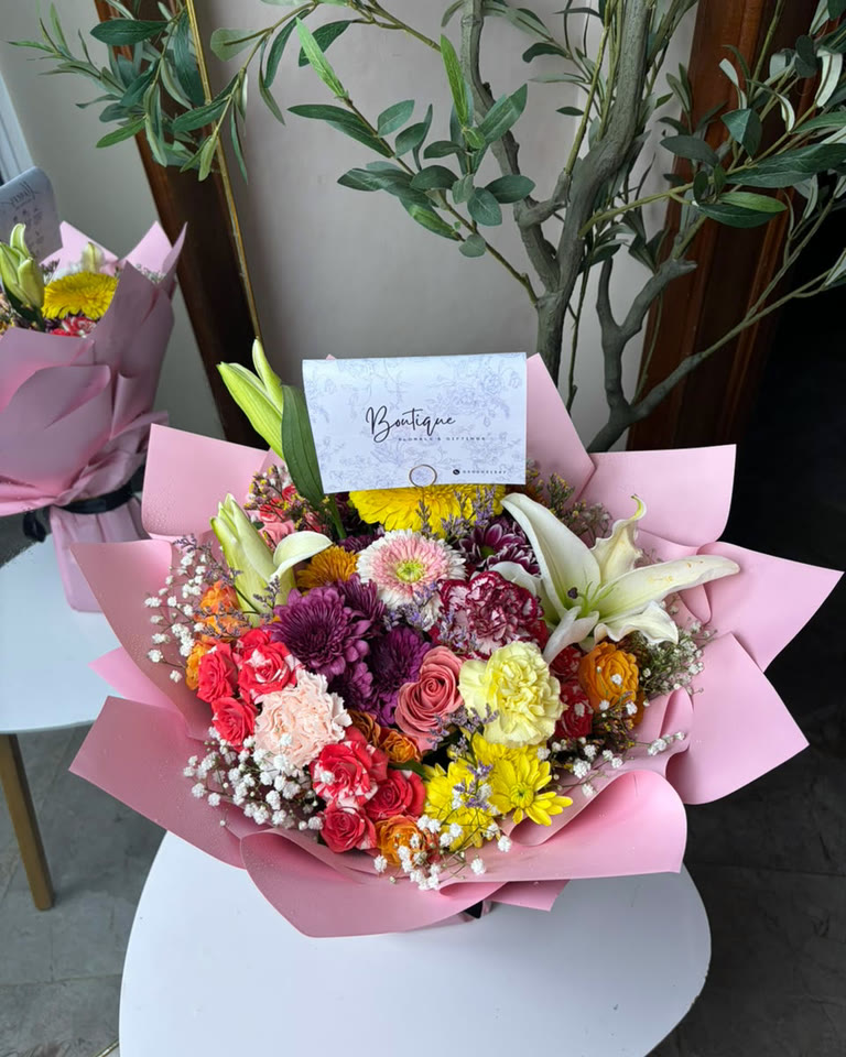 A handwritten card tucked into a bouquet before it leaves the studio