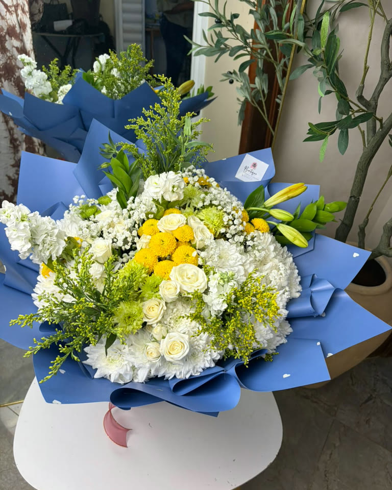 A white and green arrangement finished on the studio stand