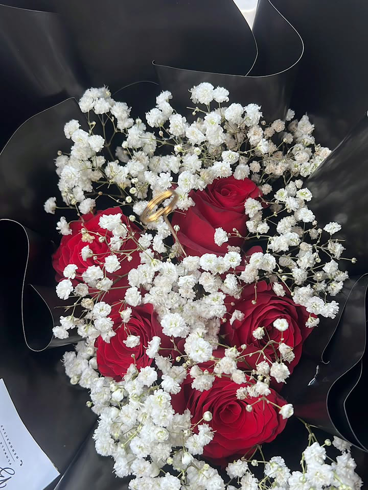 Red roses and gypsophila wrapped in black for an anniversary in Accra